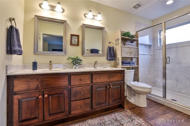 bathroom featuring a shower with door, wood-type flooring, vanity, and toilet