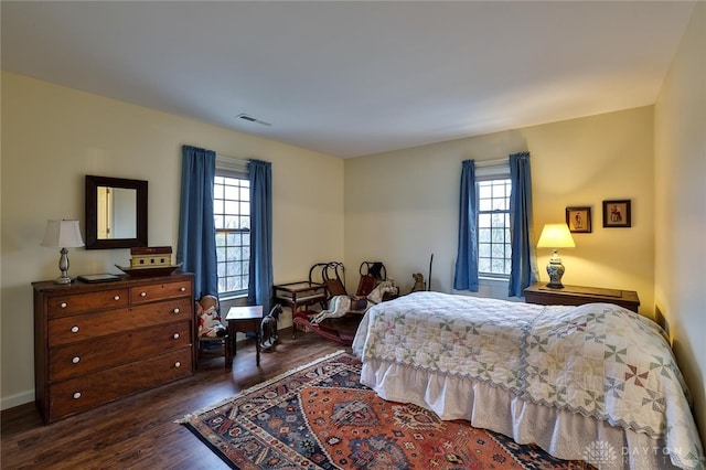 bedroom featuring dark hardwood / wood-style flooring and multiple windows