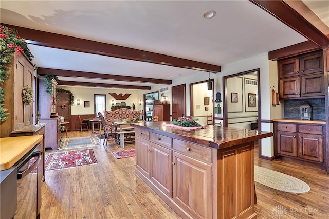 kitchen with dishwashing machine, a center island, tasteful backsplash, wood-type flooring, and beamed ceiling