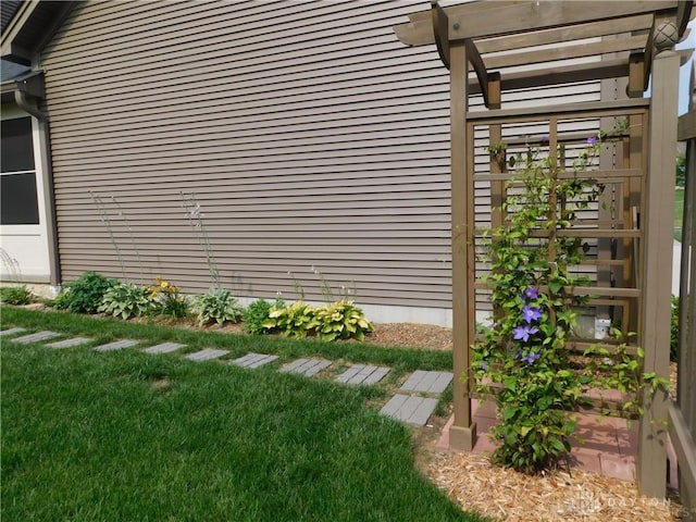 view of side of property with a pergola and a yard