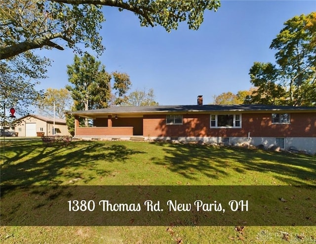 rear view of property featuring a lawn