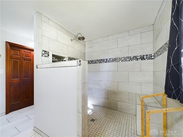 bathroom featuring tile patterned flooring and a tile shower