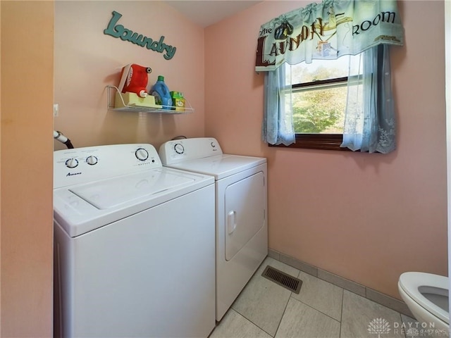 laundry area featuring light tile patterned floors and washing machine and dryer