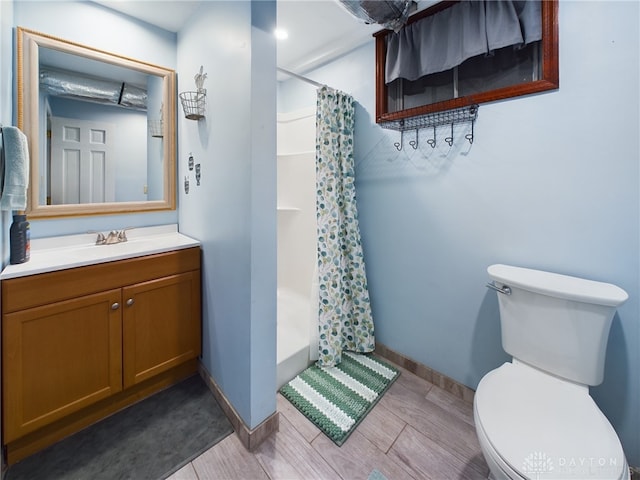 bathroom featuring vanity, curtained shower, and toilet