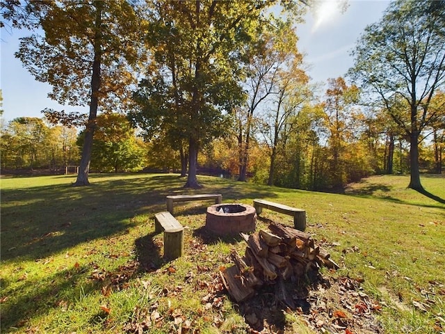 surrounding community with a yard and a fire pit