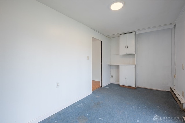 carpeted spare room with a baseboard radiator