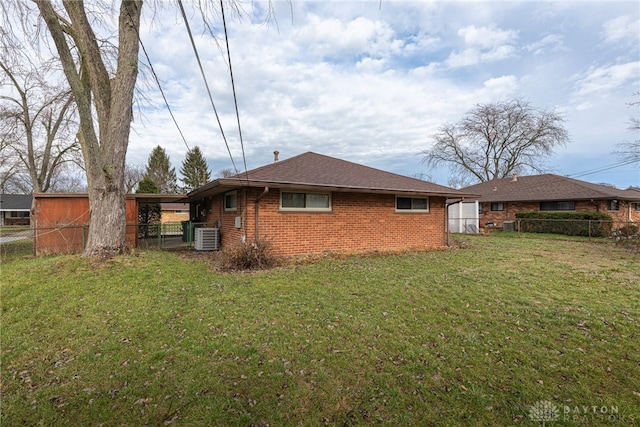 back of house featuring cooling unit and a lawn