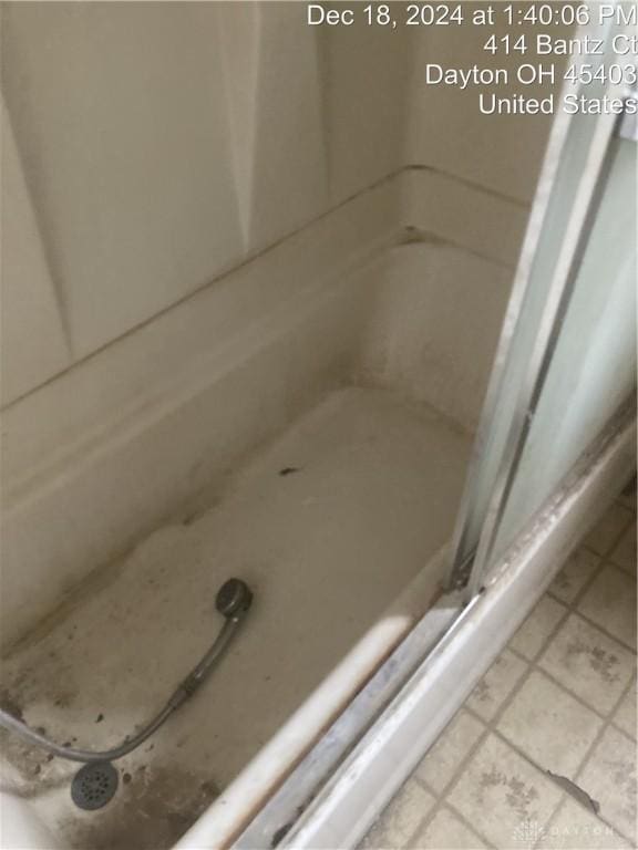 bathroom with a shower and tile patterned flooring