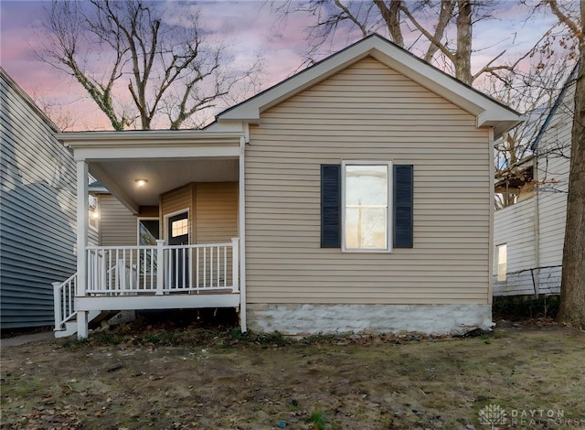 property exterior at dusk featuring a porch