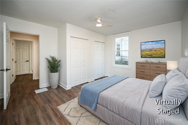 bedroom featuring two closets, ceiling fan, and dark wood-type flooring