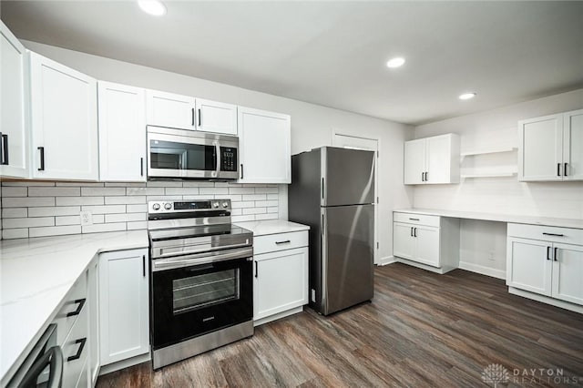 kitchen with light stone countertops, tasteful backsplash, stainless steel appliances, white cabinets, and dark hardwood / wood-style floors