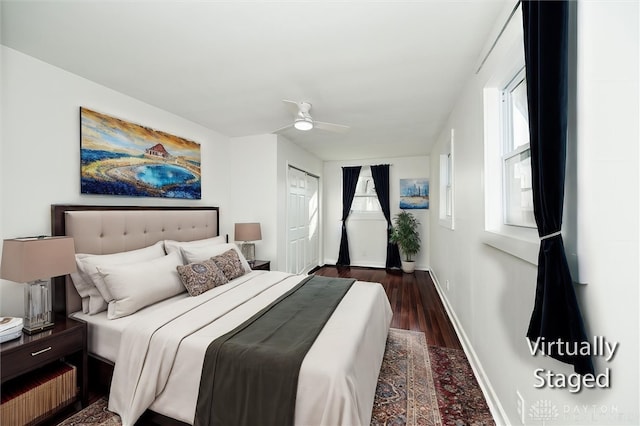 bedroom with multiple windows, ceiling fan, and dark hardwood / wood-style flooring