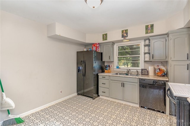 kitchen with dishwasher, black refrigerator with ice dispenser, sink, gray cabinets, and range