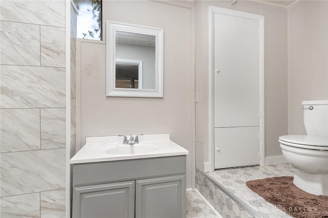 bathroom with crown molding, vanity, and toilet