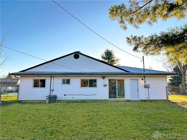 back of property featuring central AC and a yard