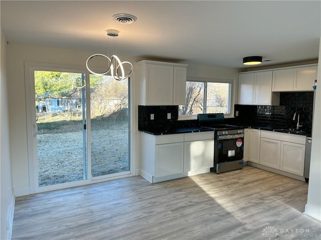 kitchen featuring white cabinetry, hanging light fixtures, and appliances with stainless steel finishes