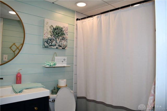 bathroom with wooden walls and toilet