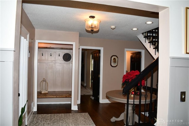 mudroom featuring dark wood-type flooring and a textured ceiling