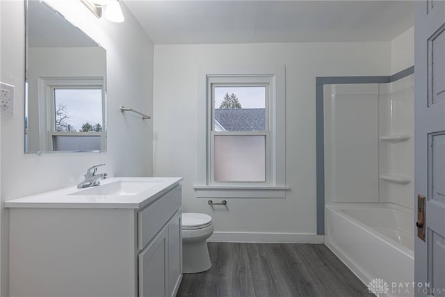 full bathroom featuring washtub / shower combination, hardwood / wood-style flooring, vanity, and toilet