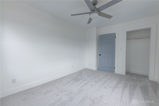 unfurnished bedroom featuring ceiling fan, a closet, and light colored carpet