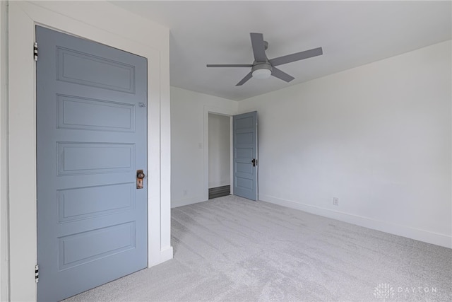 carpeted spare room with ceiling fan