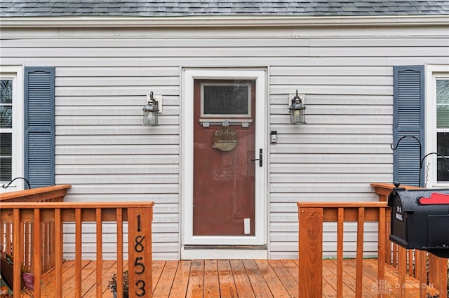 view of exterior entry featuring a wooden deck