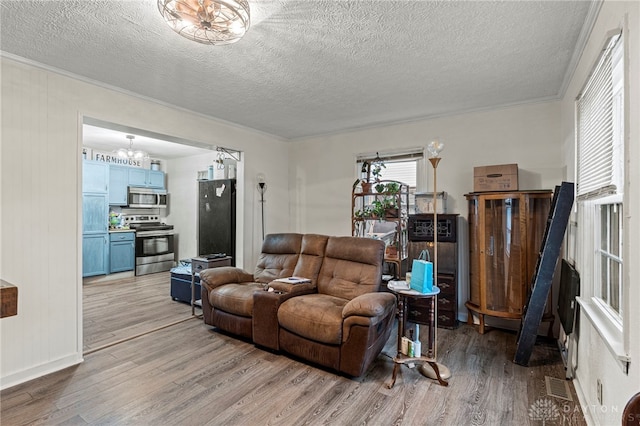 living room featuring light wood-type flooring, a textured ceiling, and a chandelier