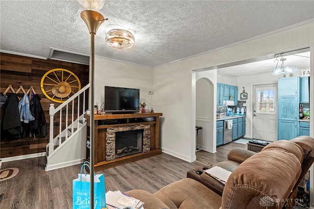 living room with a fireplace, hardwood / wood-style floors, a textured ceiling, and sink