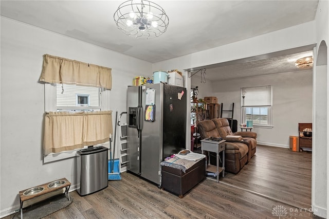 kitchen featuring stainless steel fridge, dark hardwood / wood-style flooring, and a chandelier