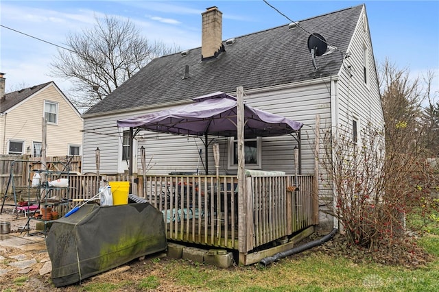 back of property with a gazebo and a wooden deck