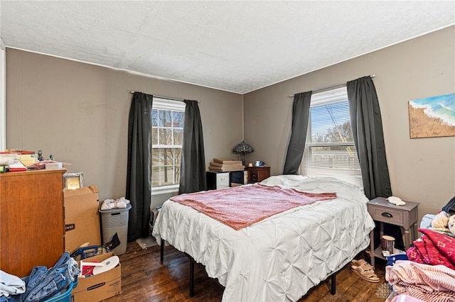 bedroom with dark hardwood / wood-style flooring and a textured ceiling