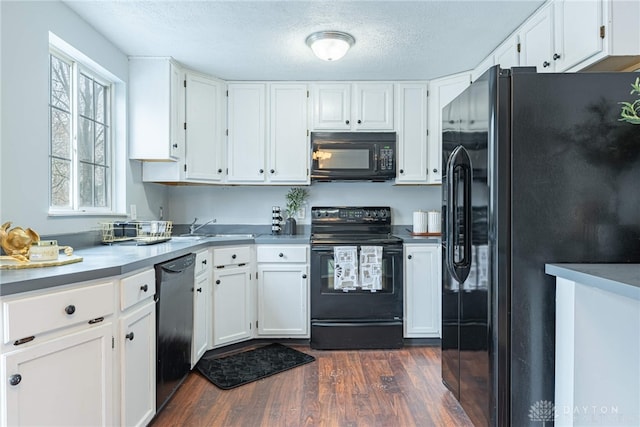 kitchen featuring black appliances, sink, dark hardwood / wood-style floors, a textured ceiling, and white cabinetry