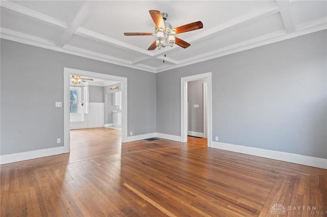 empty room with ceiling fan, coffered ceiling, beamed ceiling, wood-type flooring, and ornamental molding