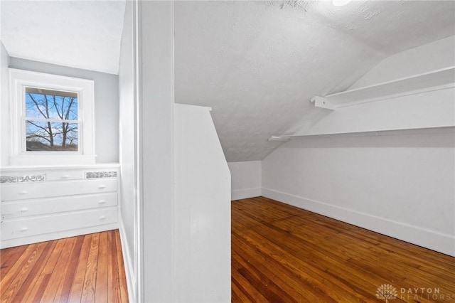 spacious closet with wood-type flooring and vaulted ceiling