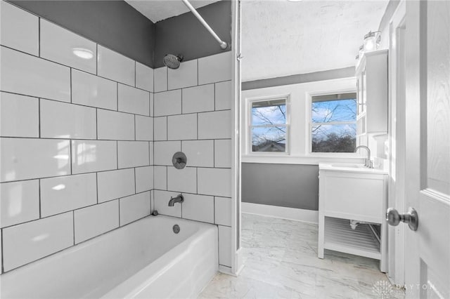 bathroom featuring vanity, a textured ceiling, and tiled shower / bath