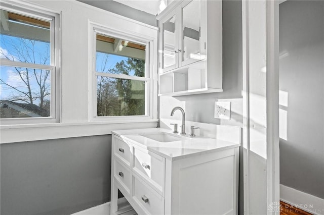 interior space with white cabinets, light stone countertops, and sink