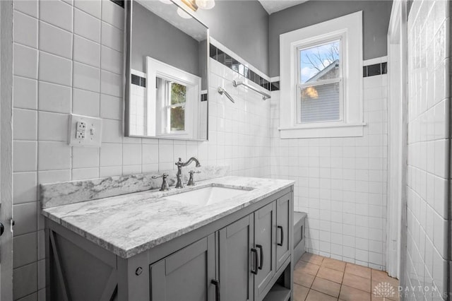 bathroom featuring tile patterned flooring, vanity, and tile walls