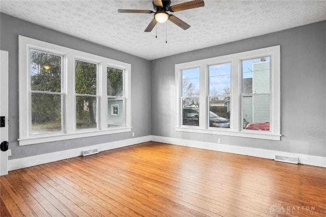 spare room with ceiling fan, wood-type flooring, and a textured ceiling