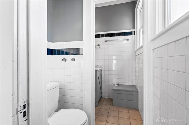 bathroom with tile patterned floors, tile walls, and toilet