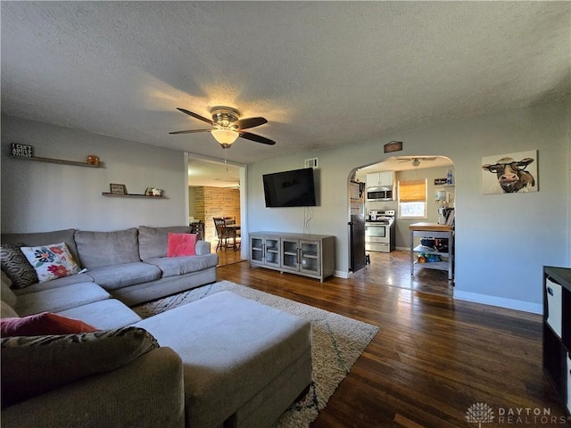 living room featuring hardwood / wood-style floors, ceiling fan, and a textured ceiling