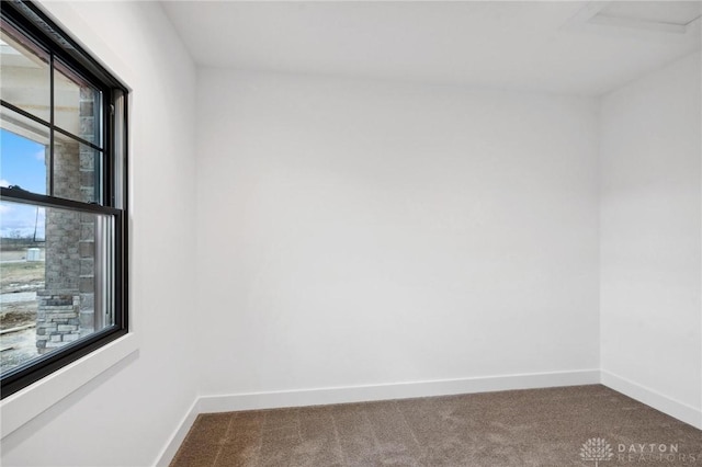 spare room with baseboards and carpet