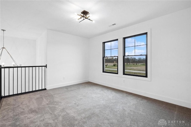 empty room with carpet floors, baseboards, and visible vents
