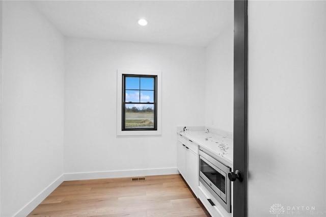 laundry area featuring recessed lighting, baseboards, visible vents, and light wood-style flooring