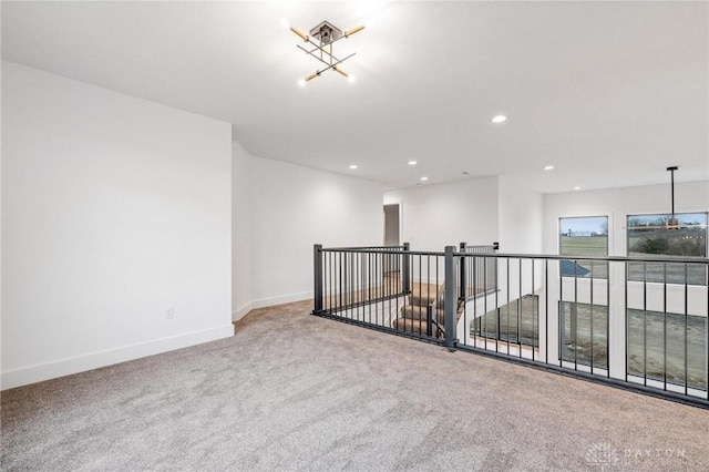 spare room with recessed lighting, carpet flooring, baseboards, and a chandelier