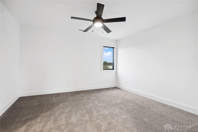 carpeted empty room featuring baseboards and ceiling fan