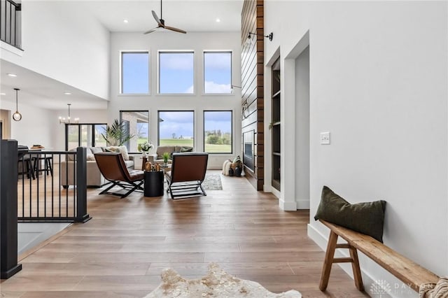living area featuring recessed lighting, a high ceiling, ceiling fan, and wood finished floors