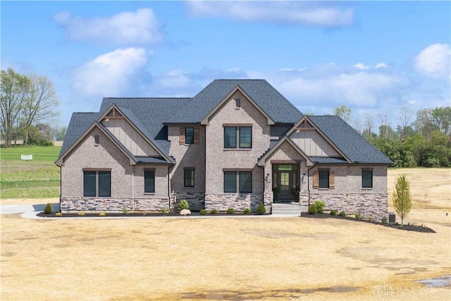 craftsman inspired home with a shingled roof, board and batten siding, and stone siding