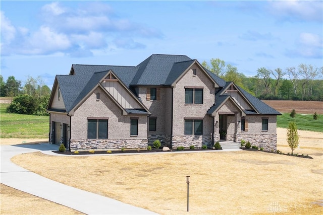 craftsman-style home featuring board and batten siding, driveway, and stone siding