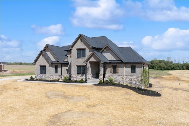 craftsman-style home with a shingled roof and stone siding