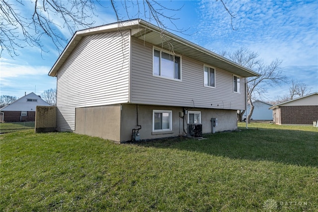 rear view of property featuring cooling unit and a yard